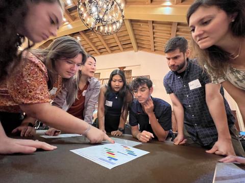 Students working around a table together. 