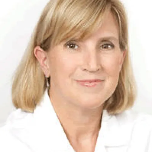 Woman in white blouse with a subtle smile. 